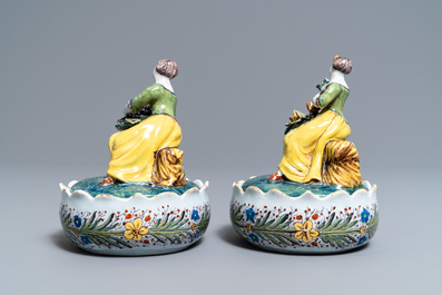 A pair of polychrome Dutch Delft butter tubs with ladies selling flowers and fruits, 18th C.