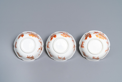 Three Chinese iron red eggshell cups and saucers with boys and goats, Yongzheng