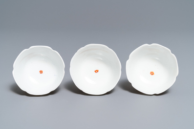 Three Chinese iron red eggshell cups and saucers with boys and goats, Yongzheng