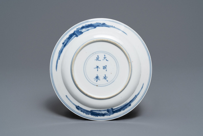 Une assiette en porcelaine de Chine bleu et blanc &agrave; d&eacute;cor de p&ecirc;cheurs, marque de Chenghua, Kangxi