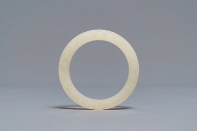 A Chinese inscribed white jade ring, 19/20th C.