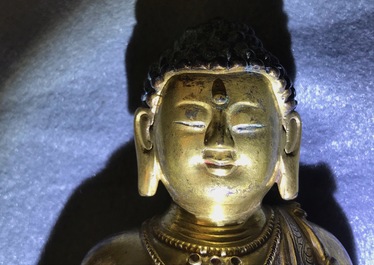 Een Chinese verguld bronzen figuur van een staande Boeddha met inscriptie, Qianlong