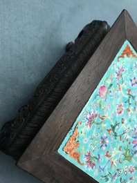 A Chinese carved wooden stand with famille rose plaque, 19th C.