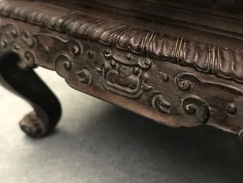 A Chinese carved wooden stand with famille rose plaque, 19th C.