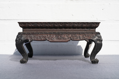 A Chinese carved wooden stand with famille rose plaque, 19th C.