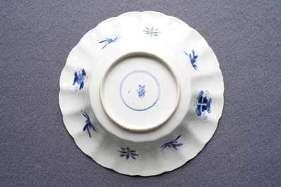 Two Chinese blue and white gadrooned 'crabs and carps' dishes and a pair of plates, Kangxi