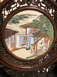 A Chinese carved wooden screen with a famille rose plaque, 19/20th C.