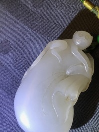 Un pendentif en jade blanc figurant un singe sur une pochette, Qing