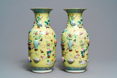 A pair of Chinese yellow-ground famille rose relief-decorated vases, 19th C.
