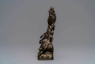 Een Chinese bronzen figuur van Guanyin op een kylin, Ming