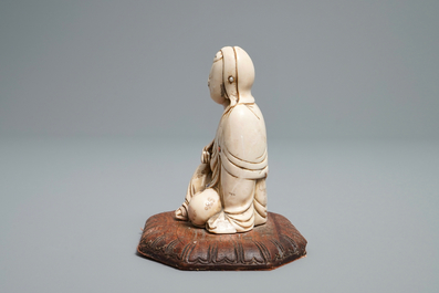 A Chinese inlaid soapstone figure of a seated deity, 17/18th C.