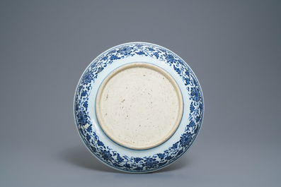 Un plat en porcelaine de Chine bleu et blanc &agrave; d&eacute;cor de rinceaux floraux de style Ming, Qianlong