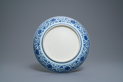 Un plat en porcelaine de Chine bleu et blanc &agrave; d&eacute;cor de rinceaux floraux de style Ming, Qianlong