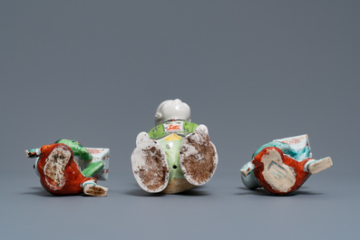 A pair of Chinese blue and white candlesticks and three famille rose figures of boys, 19th C.