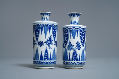 Een paar Chinese blauw-witte rouleau vazen met emblemen, Kangxi