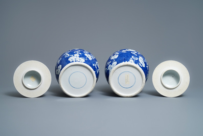 A pair of Chinese blue and white 'prunus on cracked ice' vases and covers, 19th C.