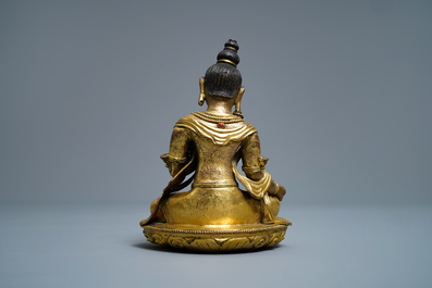 A Sino-Tibetan coral- and turquoise-inlaid gilt bronze figure of Tara, 18th C.