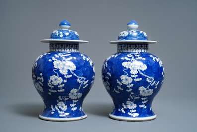 A pair of Chinese blue and white 'prunus on cracked ice' vases and covers, 19th C.