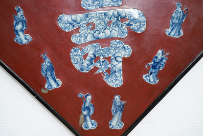 Une plaque laqu&eacute;e rouge incrust&eacute;e de porcelaine de Chine en bleu et blanc, 19/20&egrave;me