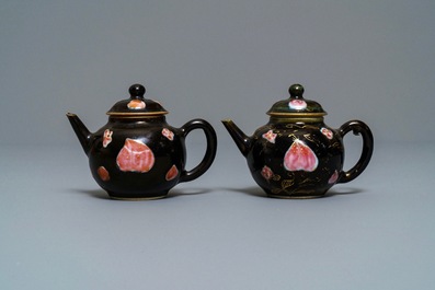 Une paire de th&eacute;i&egrave;res en porcelaine de Chine famille rose sur fond noir, Yongzheng/Qianlong