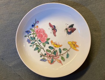 A Chinese famille rose 'ruby back' saucer dish with butterflies among flowers, Yongzheng