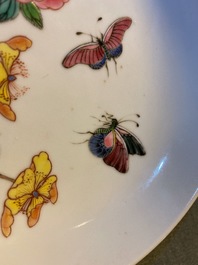 A Chinese famille rose 'ruby back' saucer dish with butterflies among flowers, Yongzheng