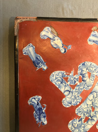 A Chinese red-lacquered plaque with blue and white porcelain inserts, 19/20th C.