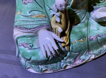 A Chinese verte biscuit group of Guanyin with child on a lotus throne, Kangxi