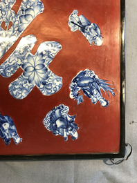 A Chinese red-lacquered plaque with blue and white porcelain inserts, 19/20th C.