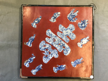 Une plaque laqu&eacute;e rouge incrust&eacute;e de porcelaine de Chine en bleu et blanc, 19/20&egrave;me