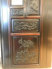 Une armoire en bois sculpt&eacute; orn&eacute;e de 23 plaques en porcelaine de Chine qianjiang cai, 19/20&egrave;me