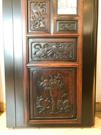 Une armoire en bois sculpt&eacute; orn&eacute;e de 23 plaques en porcelaine de Chine qianjiang cai, 19/20&egrave;me