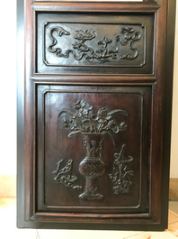 Une armoire en bois sculpt&eacute; orn&eacute;e de 23 plaques en porcelaine de Chine qianjiang cai, 19/20&egrave;me