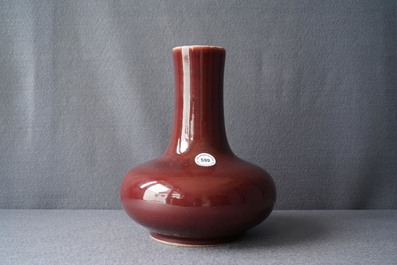 Un vase de forme bouteille en porcelaine de Chine rouge monochrome, Kangxi