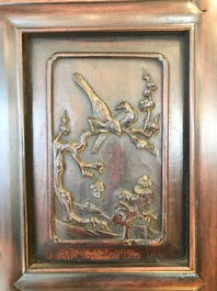 Une armoire en bois sculpt&eacute; orn&eacute;e de 23 plaques en porcelaine de Chine qianjiang cai, 19/20&egrave;me