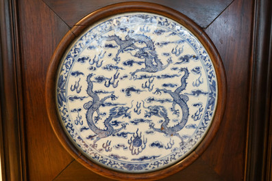 Un paravent en bois orn&eacute; de plaques en porcelaine de Chine en bleu et blanc, 19&egrave;me