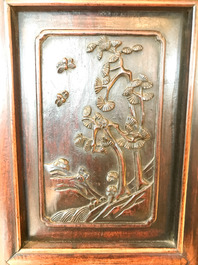 Une armoire en bois sculpt&eacute; orn&eacute;e de 23 plaques en porcelaine de Chine qianjiang cai, 19/20&egrave;me