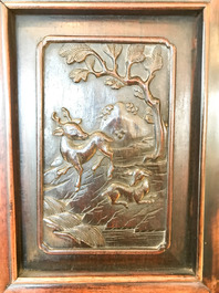 Une armoire en bois sculpt&eacute; orn&eacute;e de 23 plaques en porcelaine de Chine qianjiang cai, 19/20&egrave;me