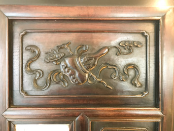 Une armoire en bois sculpt&eacute; orn&eacute;e de 23 plaques en porcelaine de Chine qianjiang cai, 19/20&egrave;me