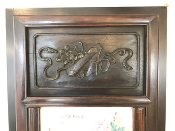 Une armoire en bois sculpt&eacute; orn&eacute;e de 23 plaques en porcelaine de Chine qianjiang cai, 19/20&egrave;me