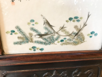 Une armoire en bois sculpt&eacute; orn&eacute;e de 23 plaques en porcelaine de Chine qianjiang cai, 19/20&egrave;me