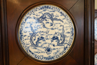 Un paravent en bois orn&eacute; de plaques en porcelaine de Chine en bleu et blanc, 19&egrave;me