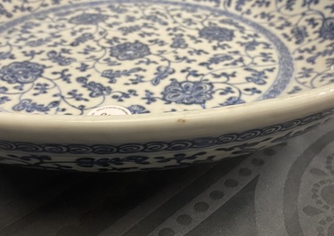 Un plat en porcelaine de Chine bleu et blanc &agrave; d&eacute;cor de rinceaux floraux de style Ming, Qianlong