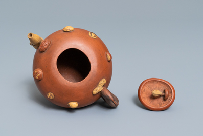 A Chinese Yixing stoneware relief-decorated teapot with nuts and fruits, impressed mark, 19th C.
