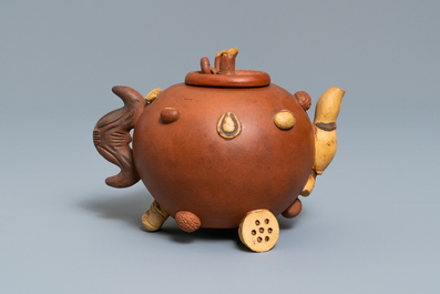 A Chinese Yixing stoneware relief-decorated teapot with nuts and fruits, impressed mark, 19th C.