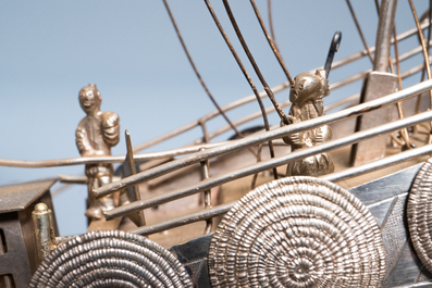 A large Chinese silver model of a junk on carved wooden stand, 19th C.