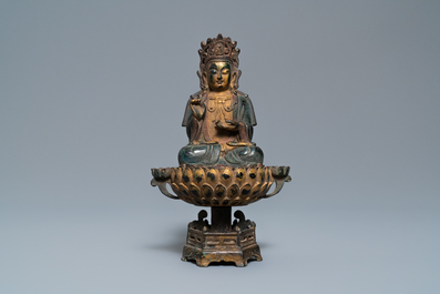 Een Chinese vergulde en deels polychrome bronzen figuur van Boeddha op een lotustroon, Qing