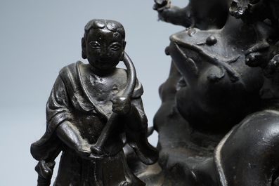 Een grote Chinese bronzen groep met Guanyin met kind op een rots, Ming