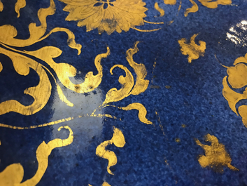 Een Chinese poederblauwe en vergulde schotel met floraal decor, Kangxi