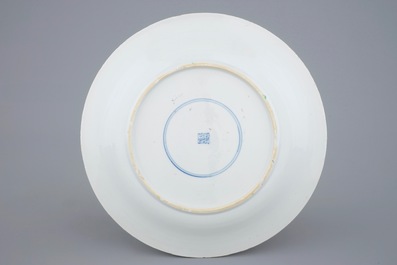 Un plat en porcelaine de Chine famille verte &agrave; d&eacute;cor d'une carpe entour&eacute;e de chevaux et lions bouddhistes, Kangxi